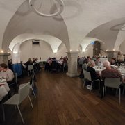 Die Mitglieder sitzen an den gedeckten Tischen und unterhalten sich angeregt