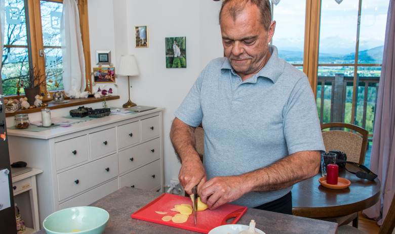 Un homme coupe une pomme de terre